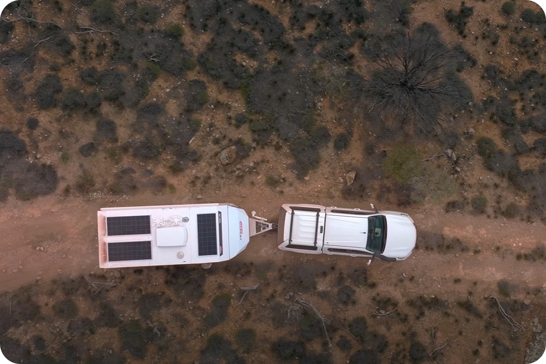 The Pioneer Campers Verve under tow on a red dirt track