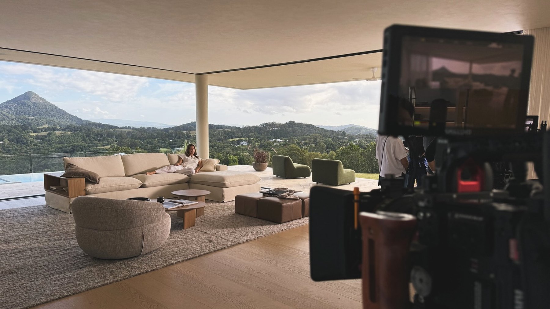 A camera and monitor set up on location, looking out over a valley at golden hour