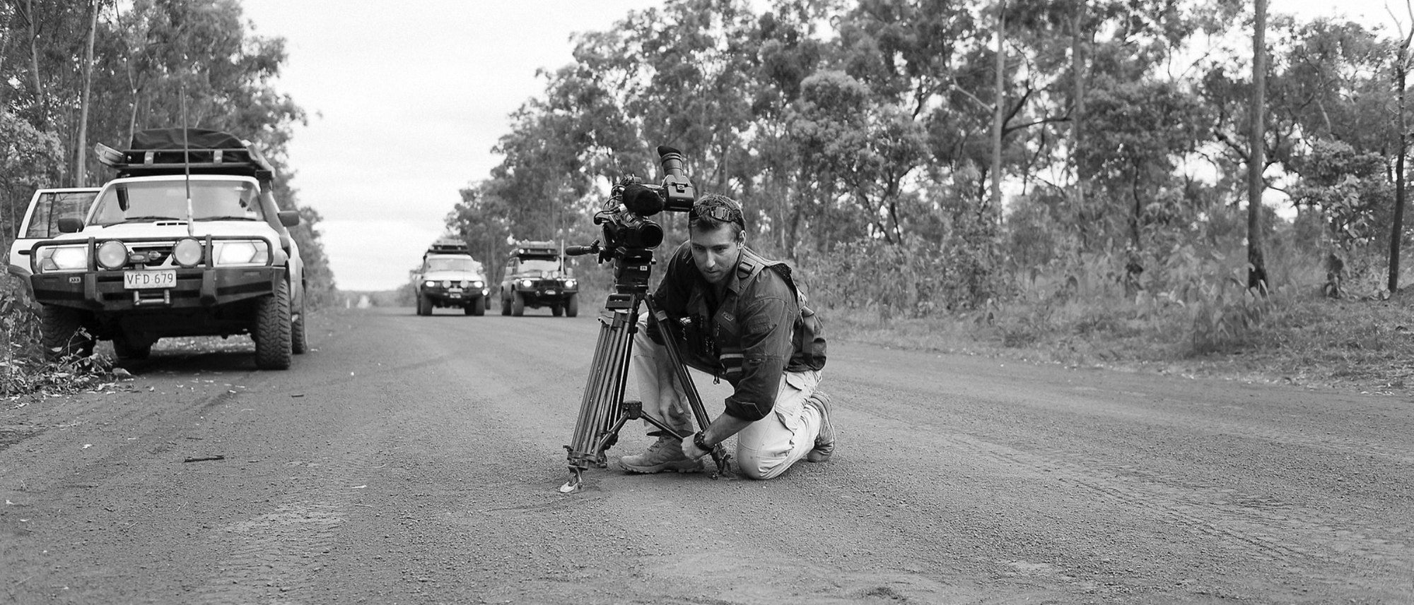 Shawn Peach shooting a four-wheel-drive convoy from the roadside on a dirt track