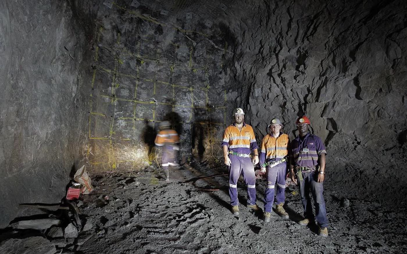 Three miners lit for a portrait underground
